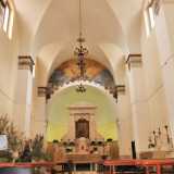 Varchiamo l'entrata, ritrovandoci in un ambiente a navata unica. Il bianco delle pareti e delle volte fa risaltare i lampadari di ottone...